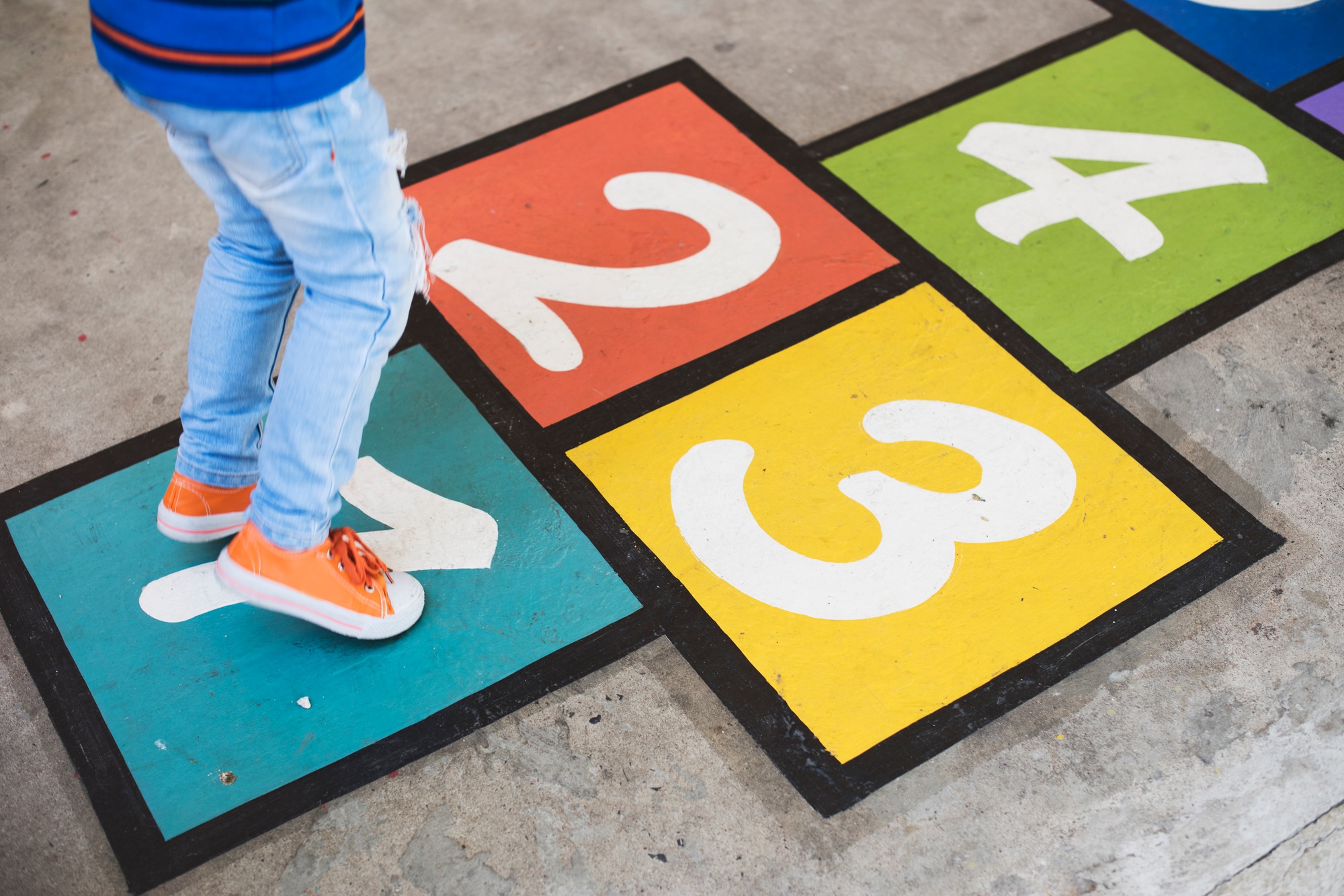 Young kid playing hopscotch